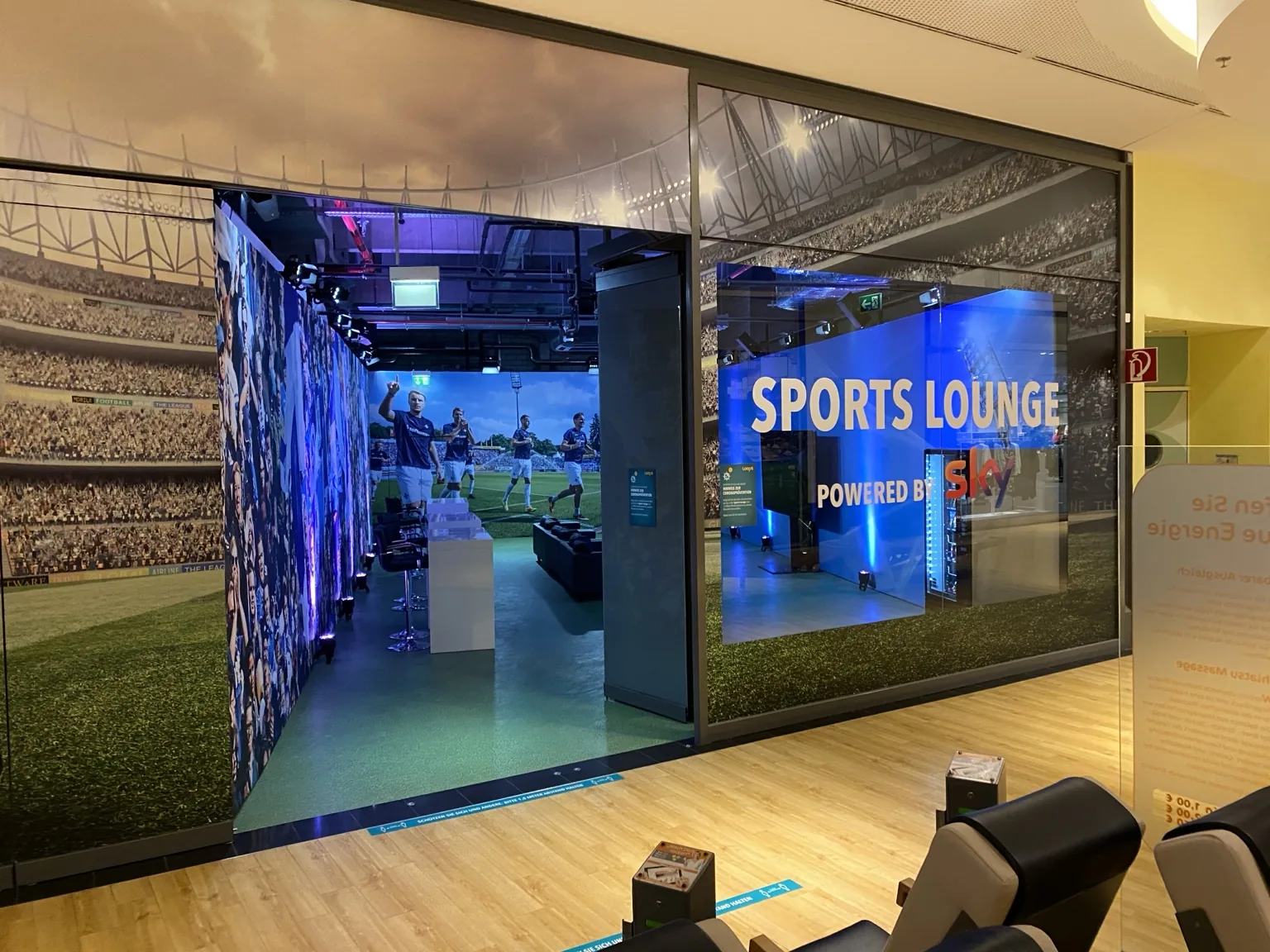 Sportlich gestalteter Markenraum mit LED-Bildschirm und Sitzbereich